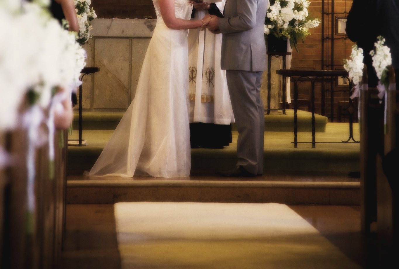 A couple holding hands at the altar