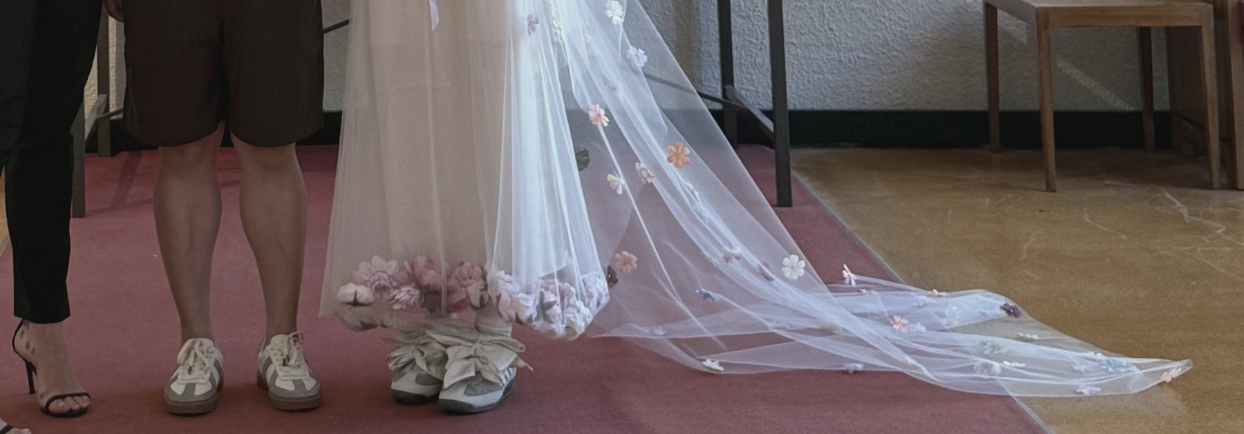 Sneakers and a flower-dotted veil on a red carpet